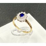 A 9ct gold ring with diamonds and central sapphire Size J
