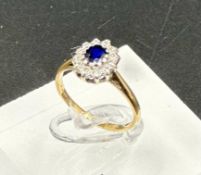 A 9ct gold ring with diamonds and central sapphire Size J