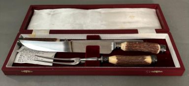 A cased horn handled carving set.