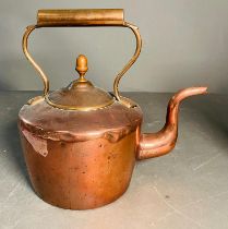 A copper plated brass kettle with lid and cooper handles with a bronze handhold