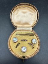 A small leather cased box with gold metal Gents shirt studs/buttons set.