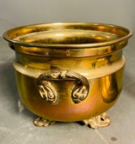 A selection of brass items to include a planter with ornate feet and handles, candle snuffer and