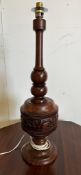 An African style wooden carved table lamp with a tribal banded relief