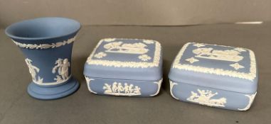 Three pieces of blue wedgwood jasperware, to covered square pots and a vase.