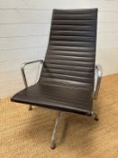 A brown leather and aluminum lounge armchair by Charles Eames for Vitra