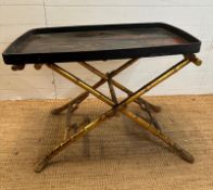 A vintage Japanese butlers tray, black lacquered and with a hand painted gilt scene depicting