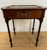 A Victorian bijouterie table with string and scrolling floral inlay on turned legs and casters