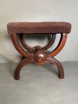 A Victorian mahogany x frame footstool finished in floral upholstery.