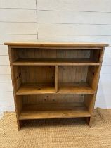 A pine three shelf bookcase, the middle shelf separated into two compartments (H102cm W96cm D31cm)