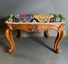 A vintage Louis style footstool, multicoloured upholstery on a carved frame with cabriole legs (