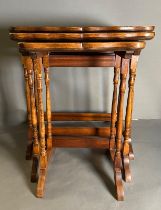 A nest of three regency style tables on turned supports