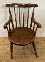 A vintage oak Penny carver arm chair, spindle back and on turned legs