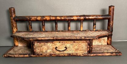 A bamboo wall hanging shelf with a single drawer and floral paper lining