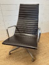 A brown leather and aluminum lounge armchair by Charles Eames for Vitra