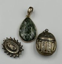 Three silver items of jewellery to include a scarab and a pendant.