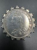 An 1887 crown coin in silver brooch mount.