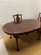 A mahogany extending dining table with two leaves, on ball and claw feet along with two carvers