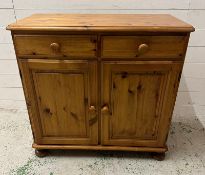 A pine two drawer cabinet with cupboard under (H84cm W89cm D44cm)
