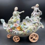 A German fine porcelain centre piece of a lady cherub on a carriage