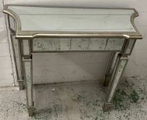 A mirrored glass console table (H79cm W90cm D35cm)