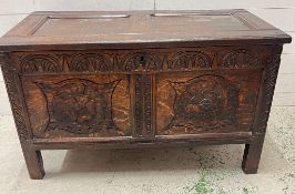 An oak coffer the front carved with Tudor rose roundels (H64cm W107cm D53cm)
