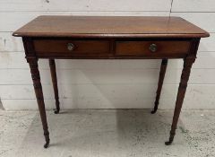 A mahogany two drawer side table on turned legs and castors (H70cm W90cm D46cm)