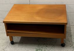 A low teak side table on castors (H38cm W75cm D50cm)