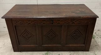 An oak coffer with three carved panels to front and hinged lid AF (H60cm W126cm D60cm)