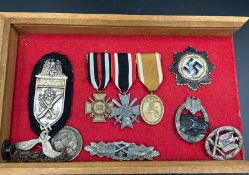 A selection of German WWII medals and military ephemera and badges.