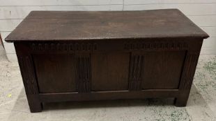 A large oak panelled coffer with hinged lid (H62cm W130cm D57cm)