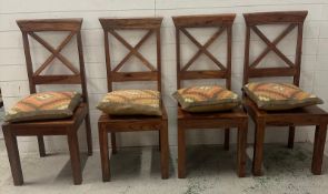 A set of four cross back hardwood dining chairs