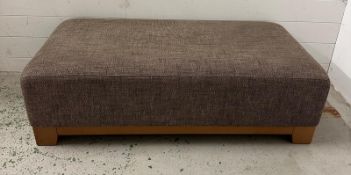 A contemporary ottoman or footstool upholstered in a chocolate and black flecked upholstery.
