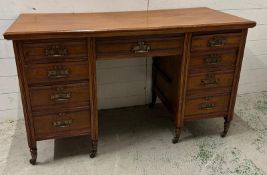 An Edwardian style pedestal desk with one long central drawer flanked by four short drawers