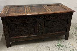 A heavily carved oak coffer with hinged lid opening to storage and internal candle box 127 L x 54