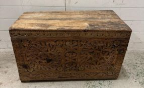 A vintage pine trunk or coffer with heavily carved front (H47cm W80cm D44cm)