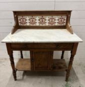 A marble topped wash stand with tiled galleried top and single cupboard under (H100cm W92cm D52cm)