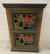 An Indian folk art painted cupboard, the doors featuring elephants in traditional costume and the