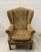A wingback arm chair with floral upholstery