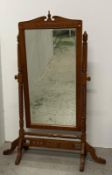 A large pine cheval dressing mirror with turned supports and on splayed triform legs 130cm x 77cm