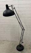 An industrial style adjustable floor lamp in black