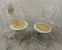A pair of folding painted metal chairs