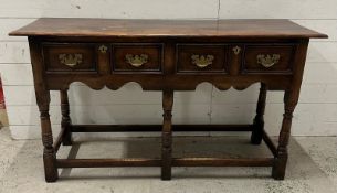 An oak William and Mary style sideboard with two long drawers, brass handles and turned legs. Height