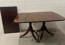 A mahogany extendable dining table on splayed legs and brass castors. 127x97. leaf 57