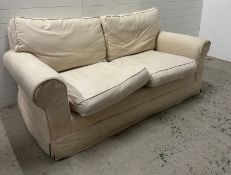 A cream two seater sofa with removable covers