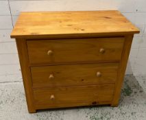 A pine chest of drawers, three long drawers with pull handles (H76cm W84cm D45cm)