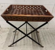 An Indian hardwood butlers trolley on black metal folding legs