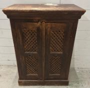 A teak maharani style two door cabinet, the colonial style lattice work front opening to a single