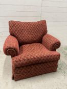 A Duresta single armchair upholstered in a red and gold hieroglyphic pattern