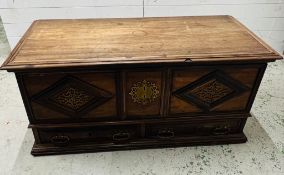 An Indian teak coffer with panelled front and drawers under (H60cm W130cm D60cm)