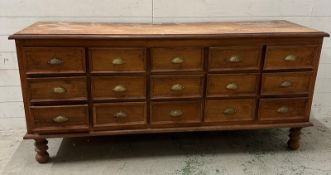 An Indian hardwood sideboard comprising of fifteen short drawers with brass cup pull handles and